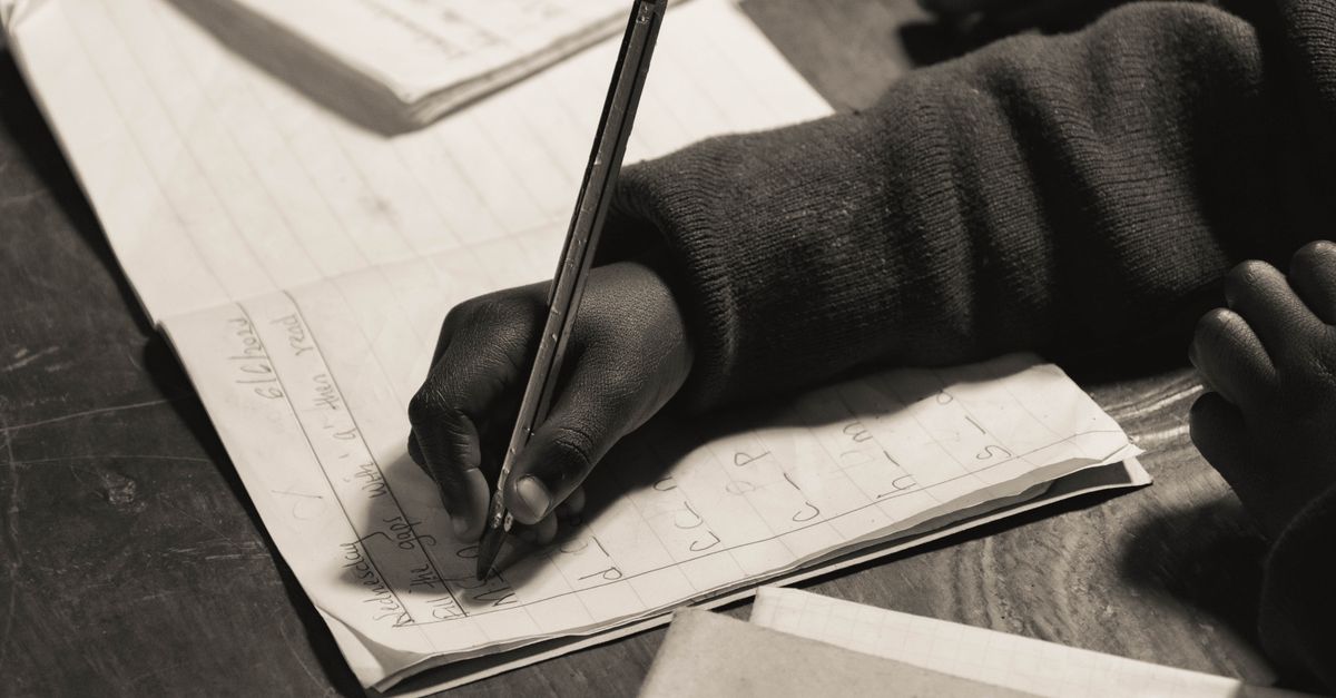 Close-up of a child writing in a notebook, focusing on handwriting practice.